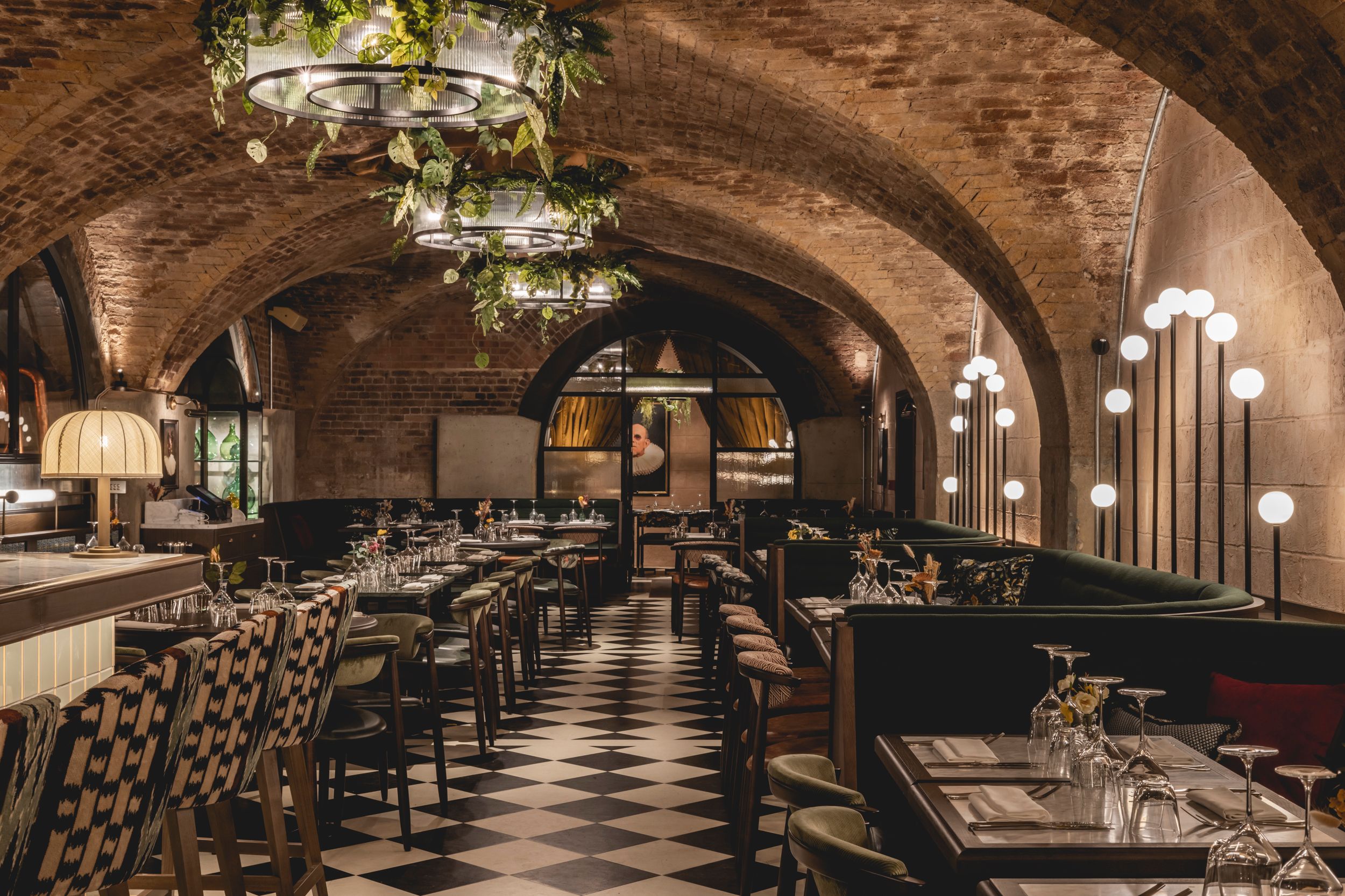 Restaurant tables laid for dining with art visible in the background.