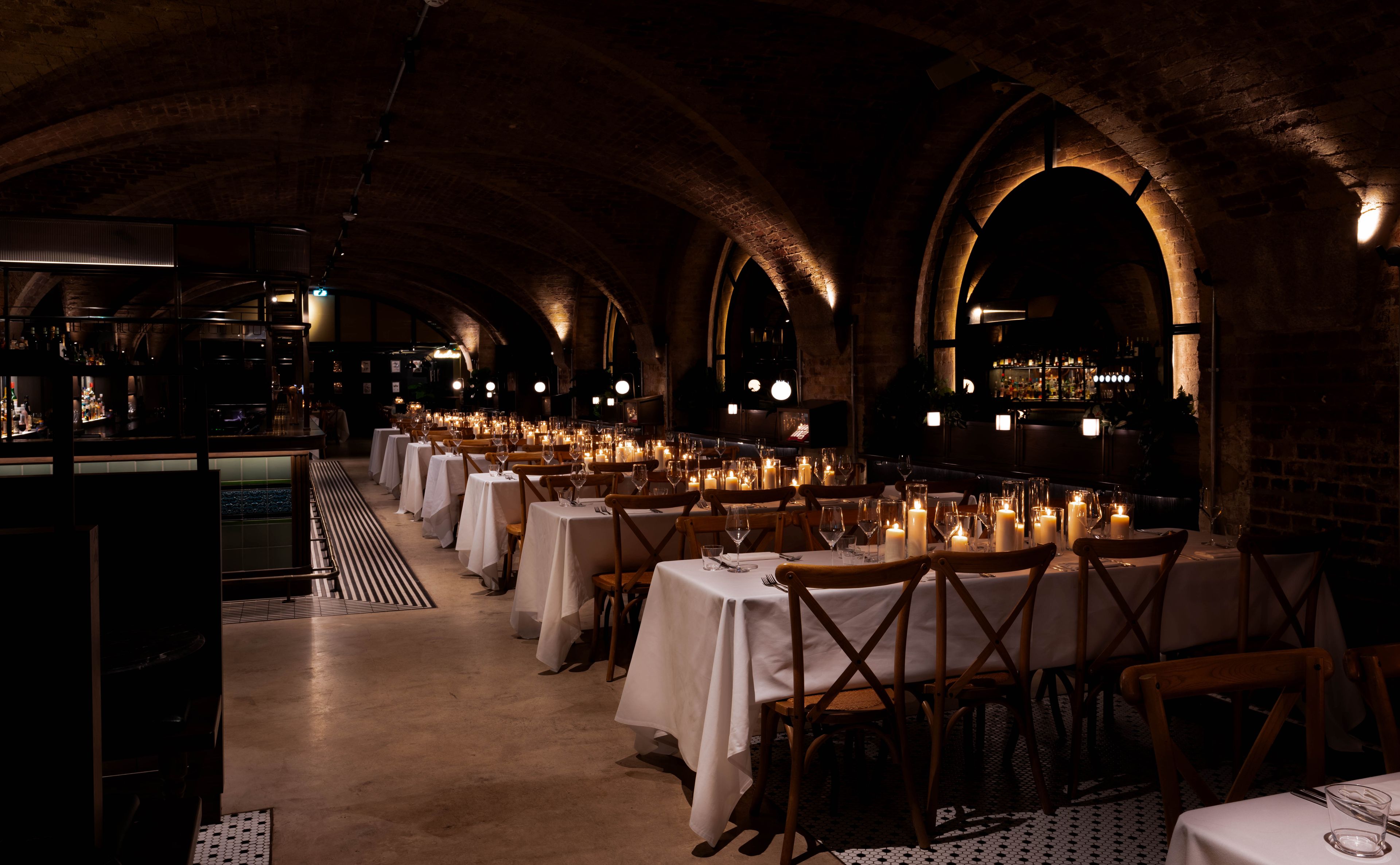Restaurant tables laid out for a wedding with candles.